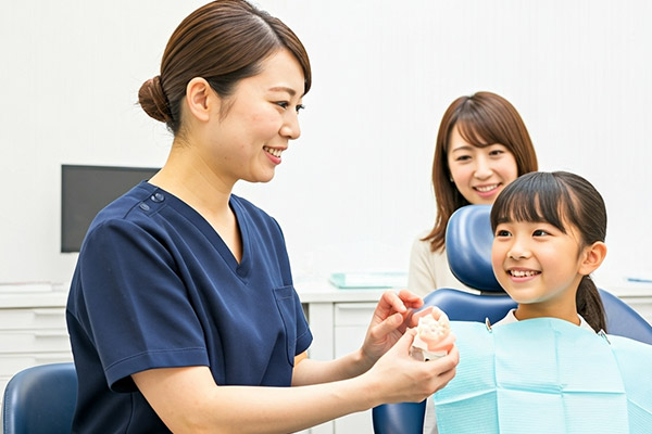 歯医者さんに説明を受ける子供と母親